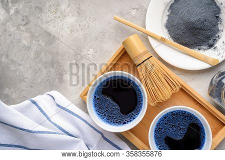 Blue Matcha Tea In Two White Cup , Wooden Tray, Bamboo Tavan And Tasaku, Powder On White Gray Backgr