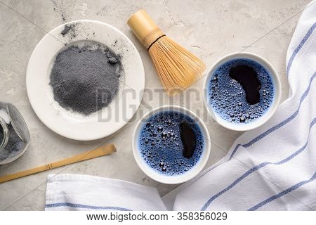 Blue Matcha Tea In Two White Cup , Wooden Tray, Bamboo Tavan And Tasaku, Powder On White Gray Backgr