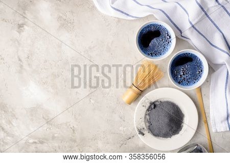 Blue Matcha Tea In Two White Cup , Wooden Tray, Bamboo Tavan And Tasaku, Powder On White Gray Backgr