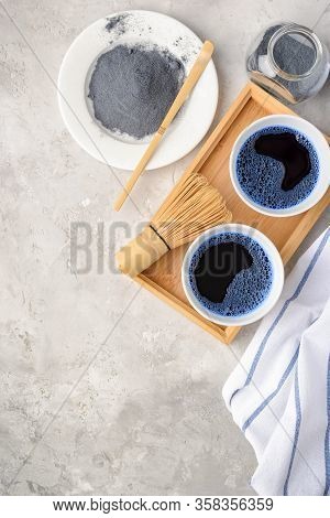 Blue Matcha Tea In Two White Cup , Wooden Tray, Bamboo Tavan And Tasaku, Powder On White Gray Backgr