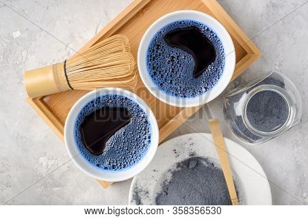 Blue Matcha Tea In Two White Cup , Wooden Tray, Bamboo Tavan And Tasaku, Powder On White Gray Backgr