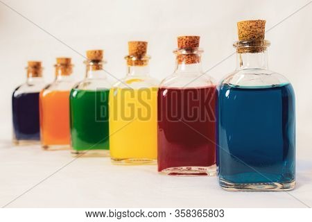 Six Glass Bottles In Perspective With Primary And Secondary Colors Blue Red Yellow Green Orange Viol