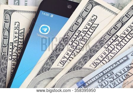 Smartphone Screen With Telegram App And Lot Of Hundred Dollar Bills. Business And Social Networking 
