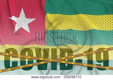 Togo Flag And Covid-19 Inscription With Orange Quarantine Border Tape. Coronavirus Or 2019-ncov Viru