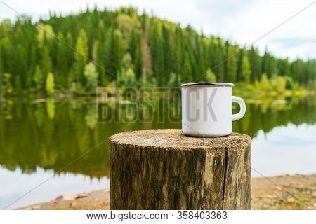 White Campfire Enamel Coffee Mug Mockup Witn The Tree Stump And River Bank View. Empty Mug Mock Up F
