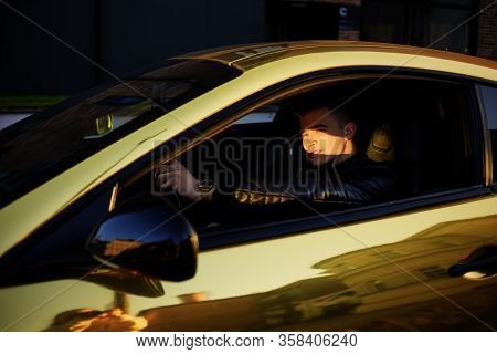 A Man Driving An Expensive Car. A Man Is Driving, A Successful Man Is Driving A Car. Golden Yellow C