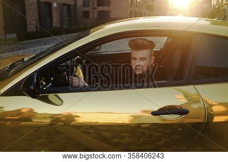 A Man Driving An Expensive Car. A Man Is Driving, A Successful Man Is Driving A Car. Golden Yellow C