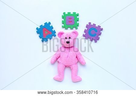 Pink Beartoy With English Alphabet Puzzle On White Background. Education Concept, Copy Space