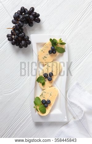 Halumi Cheese With Blueberries And Grapes On A White Plate. View From Above. The Concept Of Home-mad