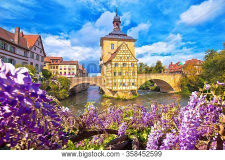 Scenic View Of Old Town Hall Of Bamberg (altes Rathaus) With Two Bridges Over The Regnitz River Flow