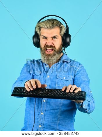 Cybersportsman. Bearded Man Headphones And Keyboard. Professional Gamer Playing Computer Game. Chat 