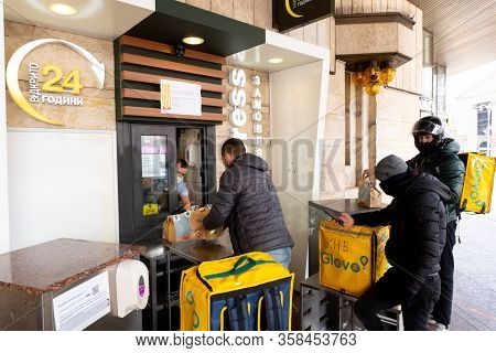 Kiev, Ukraine, March 27, 2020, Man From Mcdrive Gives Fastfood Hamburgers To Glovo Delivery Men At Q