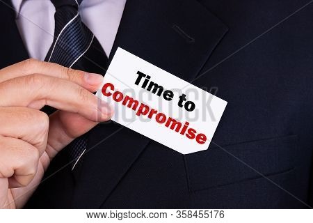 Businessman Putting A Card With Text Time To Compromise In The Pocket