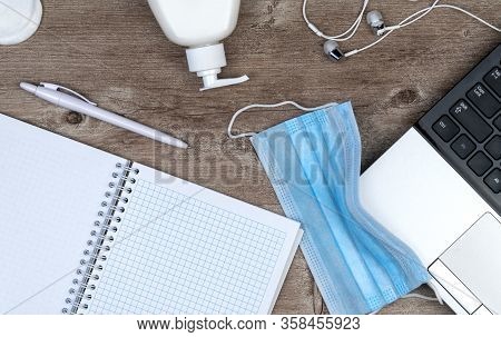 Hygiene In The Office. Remote Work Kit On Wooden Desk. Sanitizer Gel And Face Mask