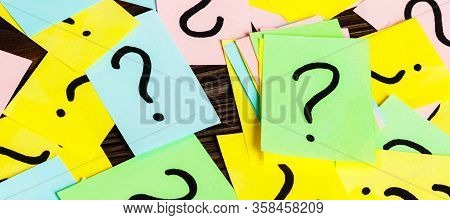 Pile Of Colorful Paper Notes With Question Marks On Wooden Background. Closeup