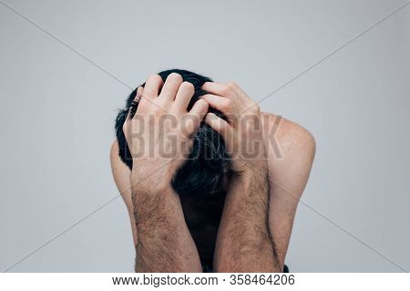 Young Man Isolated Over Background. Stressful Emotional Guy Hiding Face Down And Cover It With Hands