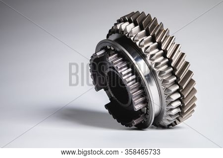New Parts On A Gray Background. Gears Of Gear Shifting Torque Transmission. Conceptually Mechanical 