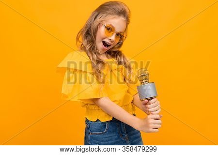 Portrait Of Young Caucaian Girl With Long Fair Hair In Yellow Glasses Smiles And Sings Songs With A 
