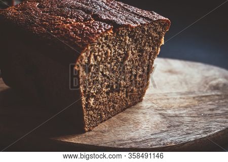 Freshly Homemade Baked Sourdough Bread On A Wooden Board. Dark Background.