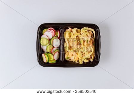 Black Plastic Container With Pasta, Shrips And Fresh Salad. Food Delivery.