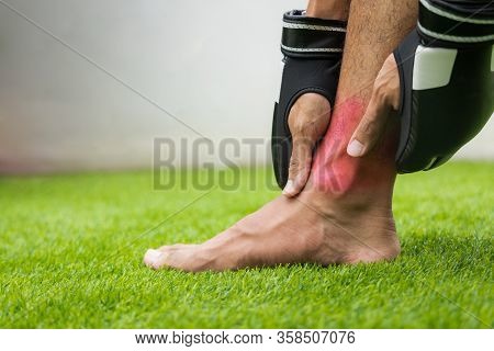 Close Up On Ankle Injury. The Man Use Hands Hold On His Ankle While Running.