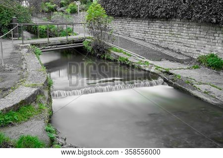 Long Exposure Of A Watefall On The River Lim Walkway At Lyme Regis In Dorset.