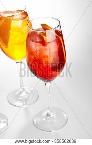 Rose Spritz cocktail. Alcohol soft drinks in glasses side view. Refreshment beverage with rose lemonade in drinkware. Exotic summer beach cocktail portions with crushed ice in glassware