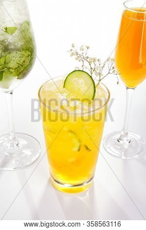 Passion fruit and cucumber cocktail close up. Alcohol drink in glass top view. Beverage with fruit juice, ice tea in drinkware. Summer beach exotic cocktail portion with crushed ice in glassware