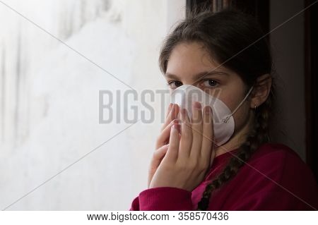 Young Girl In Home Isolation, During Quarantine Is Wearing Protective Face Mask For Stave Off Preadi