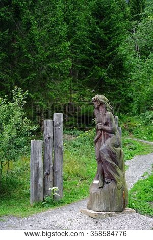 JUNFERNSPRUNG, AUSTRIA, AUGUST 18, 2019: Traditional wooden sculpteres at Jungfernsprung waterfall near Heiligenblut, Hohe Tauern National Park, Austria, Europe