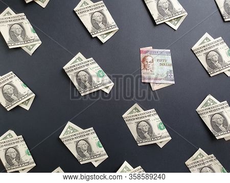 American One Dollar Bills And Jamaican Banknote Of Fifty Dollars On The Black Background