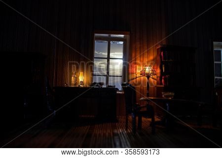 A Realistic Dollhouse Living Room With Furniture And Window At Night. Artwork Table Decoration With