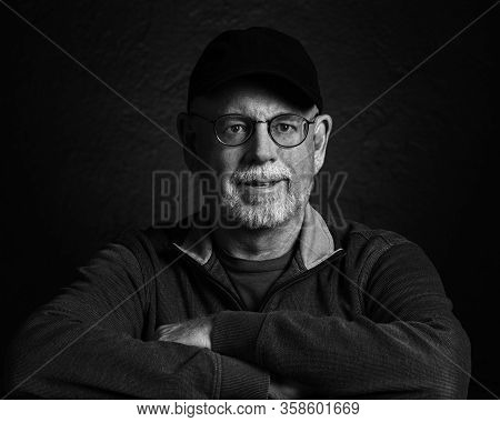 Artistic Studio Portrait Headshop Of A Cheeerful Senior In Black And White.