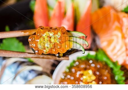Wooden Chopsticks Tongs Gunkan Maki Sushi With Salmon Caviar (ikura) And Cucumber In Japanese Food R