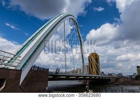 Kazakhstan, Nur-sultan - August 18, 2016: Karaotkel Bridge Near Embankment With Cloudy Sky On Backgr