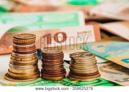 Euro Coins On Banknote Money Background, A Coin On The Background Of Stacks Of Coins And Banknotes