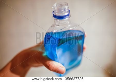 Shallow Depth Of Field Image (selective Focus) With The Hand Of A Man Holding A Plastic Bottle Of Sp