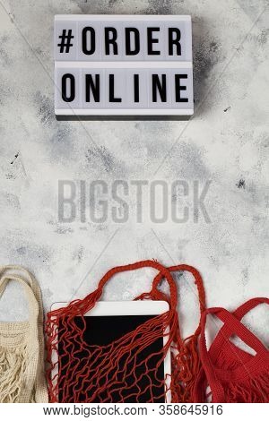 Lightbox With Words Order Online. Online Shopping Concept. Laptop In Red Mesh Shopping Bag On Blue B