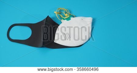 Black Mask And N 95 Mask Is Isolated On Blue Background.