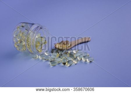 Healthy Supplements On Wooden Teaspoon On Blue Background