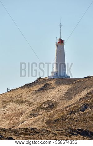 Reykjanes Lighthouse in Iceland with Gunnuhver geotermal area in the background