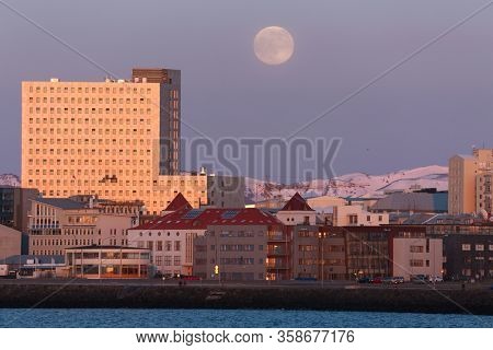 Evening view of Reykjavik with full Moon in the sky, sunset light