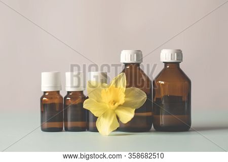Bottles Of Medicine Lined Up On A White Background. Beautiful Yellow Flower, Spring. Chemical Experi