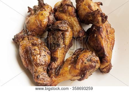 Delicious Portion Of Grilled Chicken Legs Served In A White Plate