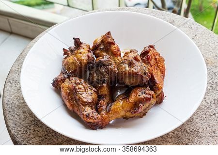 Delicious Portion Of Grilled Chicken Legs Served In A White Plate