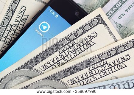 Smartphone Screen With Telegram App And Lot Of Hundred Dollar Bills. Business And Social Networking 
