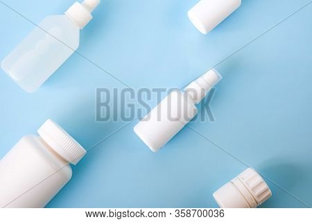 Various White Plastic Medical Containers Set On Light Blue Background. Virus Or Flu Or Cold Treatmen