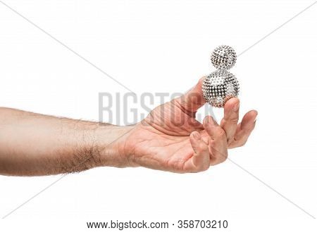 Male Hands Hold Silver Balls Similar To A Virus. The Background Is Isolated.