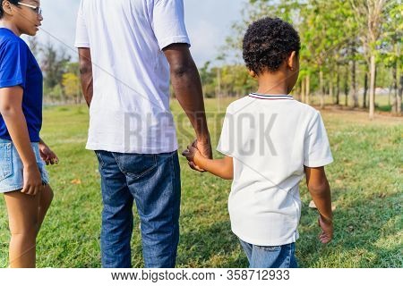 African American Father Walking In The Countrside Nature With Pre-teen Daughter And Holding Hands Wi