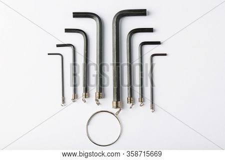 Hex Keys And A Metal Ring On A White Background.